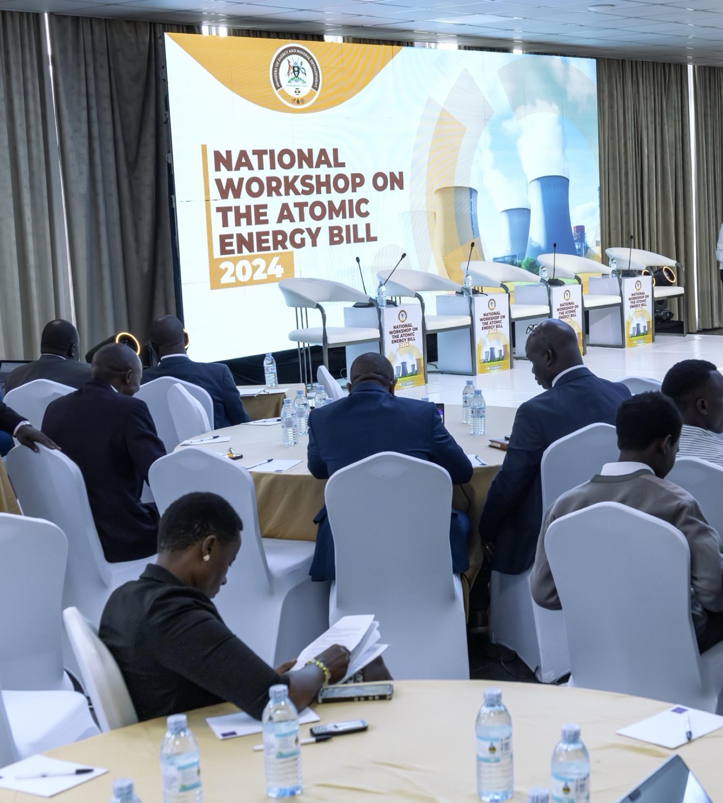 One of Skyz Hotel Kampala's conference halls in use for a corporate workshop, guests seated at round tables facing a large screen backdrop