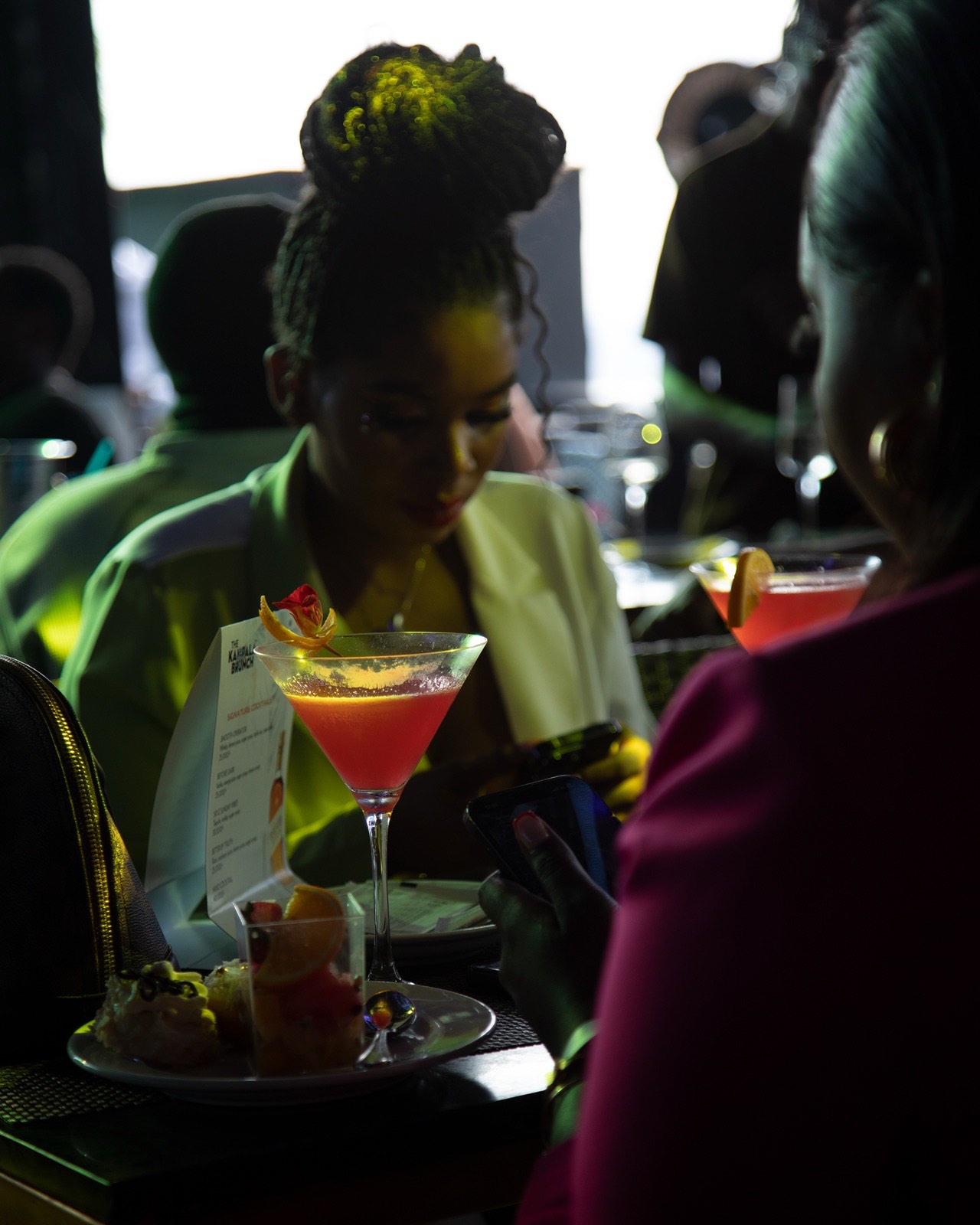 A cocktail on the table beside The Kampala Brunch drinks menu, May 2024
