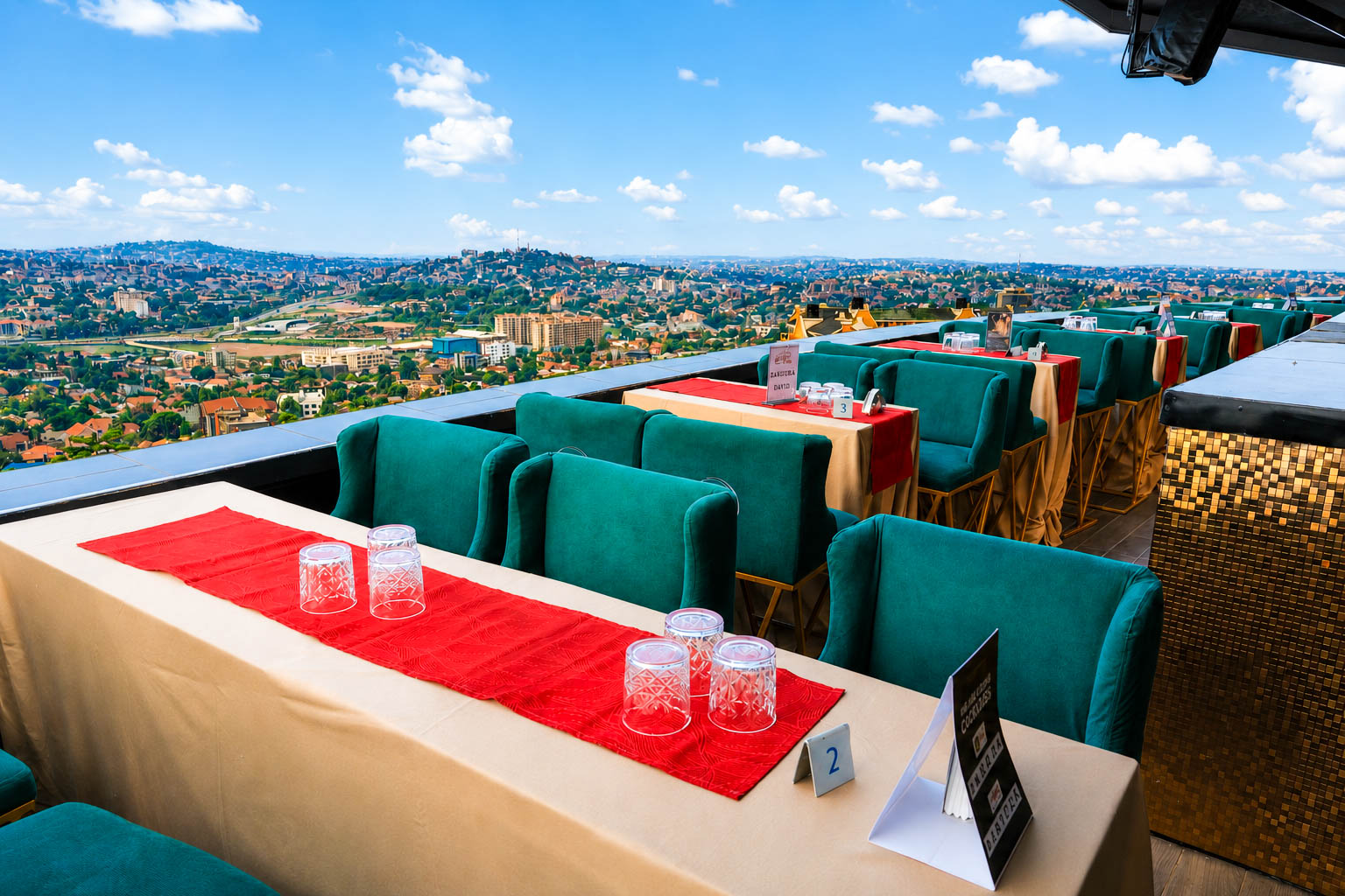 Rooftop event tables dressed in blue and white linens overlooking Kampala