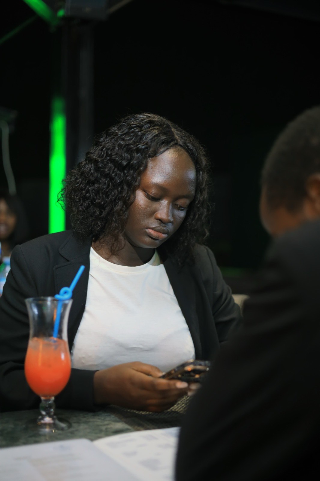 Guests at a table with drinks and answer sheets during Quiz Night at Ninety9 Rooftop Bar, city lights in the background