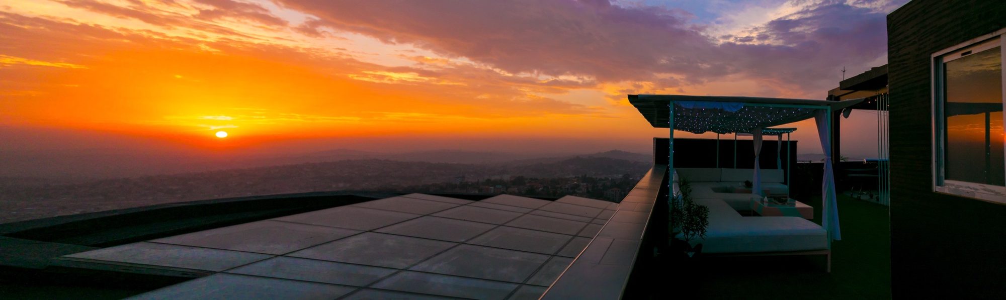 Panoramic sunset over Kampala from the Skyz rooftop, the whole city unfolding below