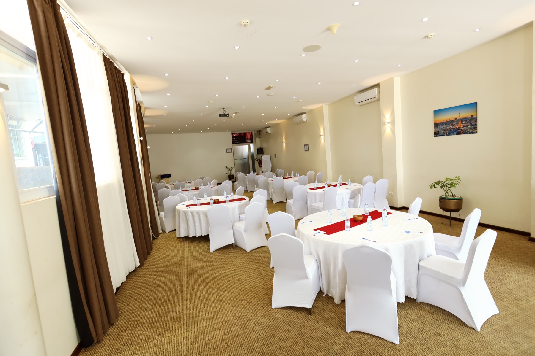 Tokyo Hall set up round-table style with the Tokyo skyline artwork on the wall